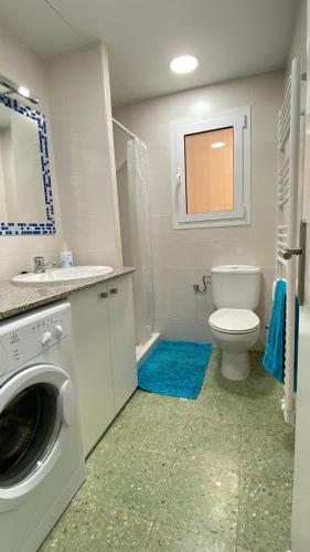 a bathroom with a washing machine and a toilet at Gran sol de la Farella in Llança