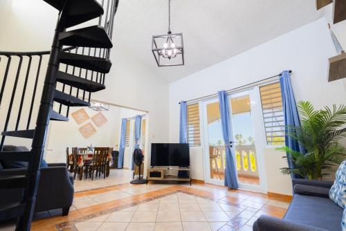 a living room with a spiral staircase and a tv at Golden Dream Villas 306/A in Isabela