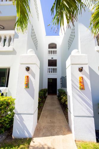 a white building with a hallway leading to a door at Golden Dream Villas 306/A in Isabela