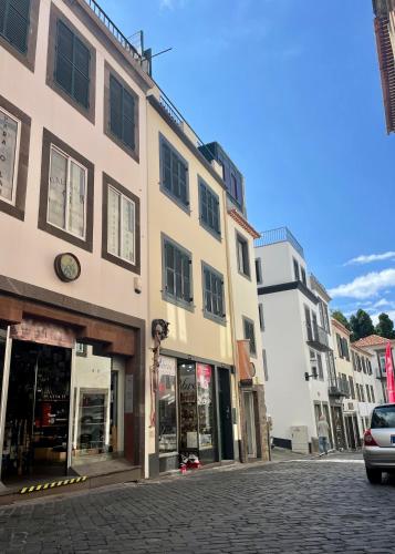 a street with buildings on a cobblestone street at Apartamento Burgo "Tanoeiros" in Funchal