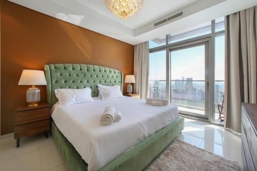 a bedroom with a large bed with a large window at Luxurious one bedroom Apartment in Dubai