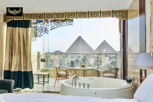 a bedroom with a tub and a view of the pyramids at Comfort Inn Giza in Cairo