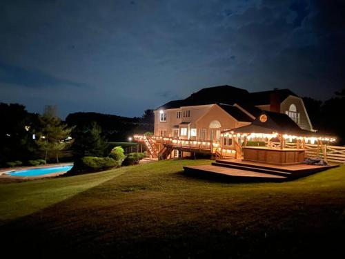 a house with a deck with lights on it at night at The Retreat at Davis Mill in Germantown