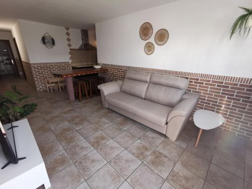 Apartamento La Condesa في أورزولا: غرفة معيشة مع أريكة وجدار من الطوب
