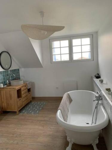une salle de bain blanche avec une baignoire et un lavabo dans l'établissement Belle maison bretonne, à Plouguerneau