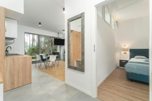 a bedroom and a living room with a bed and a mirror at Apartament Niebieski c4 in Pobierowo
