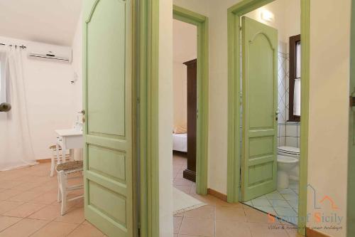 マルサラにあるVilla Giò Sicily Holidaysの緑のドア、バスルーム(トイレ付)が備わる客室です。