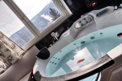 a bath tub in a bathroom with a window at Gril Ranca pod Pohorjem in Maribor