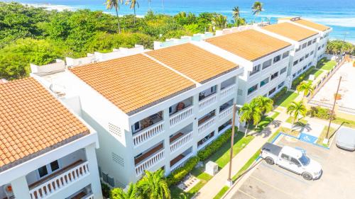 an aerial view of a white building with palm trees and the ocean at Golden Dream Villas 306/A in Isabela