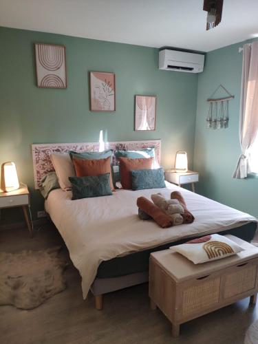 Un dormitorio con una cama grande con un osito de peluche. en LE MANHATTAN Authentique maison climatisée 78 m2, en Brasles