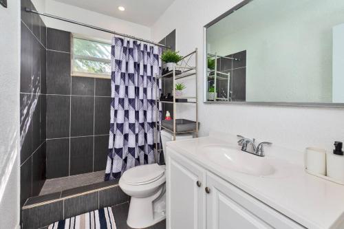 a bathroom with a sink and a toilet and a mirror at Luxurious 5 bedrooms Jacuzzipool in Miramar