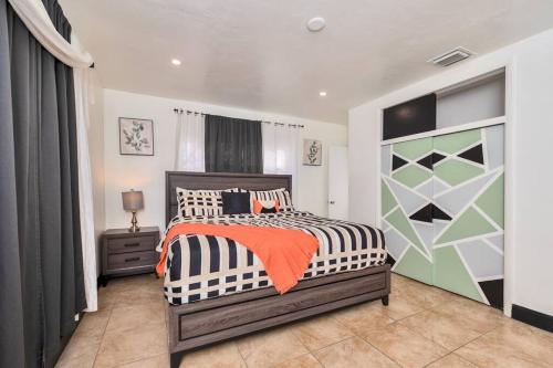 a bedroom with a bed with an orange blanket at Luxurious 5 bedrooms Jacuzzipool in Miramar