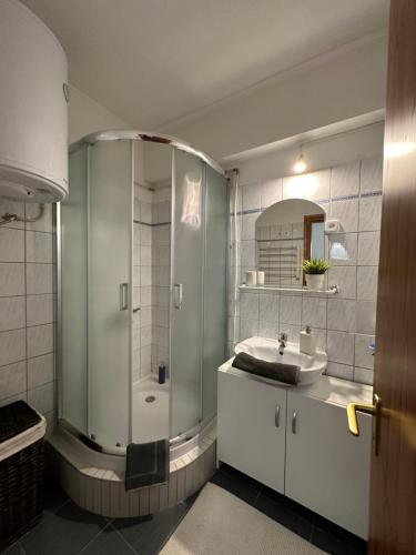 a bathroom with a shower and a sink at Central Apartman Makó in Makó