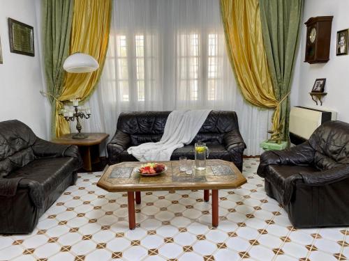 a living room with two leather couches and a coffee table at Slama in Nabeul