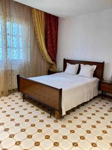 a bedroom with a bed and a tiled floor at Slama in Nabeul