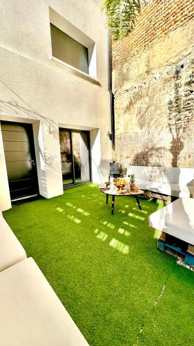 a yard with green grass next to a building at Les Gîtes de la Chapelle 4 in Vauvert