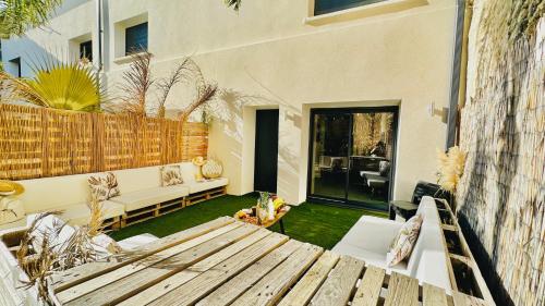 a patio with a wooden bench in a yard at Les Gîtes de la Chapelle 4 in Vauvert