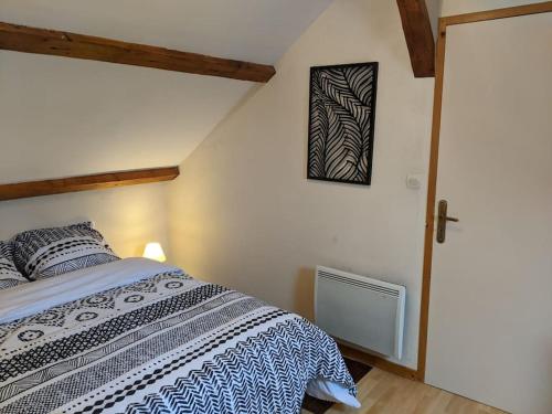 een slaapkamer met een bed en een foto aan de muur bij Nid douillet in Guéret