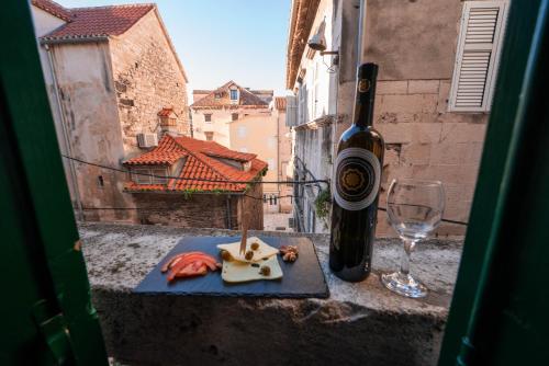 a bottle of wine and a glass on a table at Slavija Culture Heritage Hotel in Split