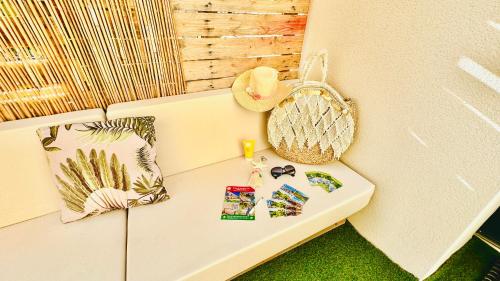 a white bench with a hat and pictures on it at Les Gîtes de la Chapelle 4 in Vauvert