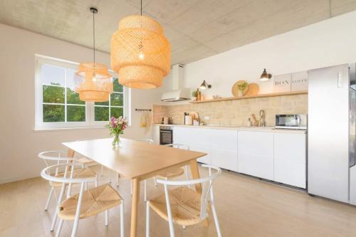 eine Küche mit einem Holztisch und weißen Schränken in der Unterkunft Villa Sunrise in Labin