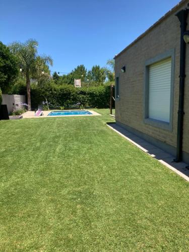 聖羅莎的住宿－Casa quinta con pileta，一个带游泳池和草地的庭院