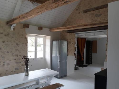 une cuisine avec un réfrigérateur en acier inoxydable dans une pièce dans l'établissement SARLAT Perigord Noir Charming Cottage PURA VIDA, à Sarlat-la-Canéda