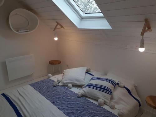 - une chambre avec un lit avec deux oreillers et une fenêtre dans l'établissement SARLAT Perigord Noir Charming Cottage PURA VIDA, à Sarlat-la-Canéda