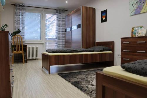 1 dormitorio con 2 camas y vestidor en Moderný priestranný apartmán, en Rimavská Sobota