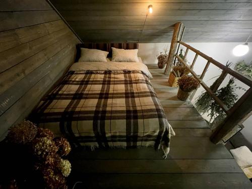 sypialnia z łóżkiem z kocem w kratę w obiekcie Tiny Barn House w Kiszyniowie