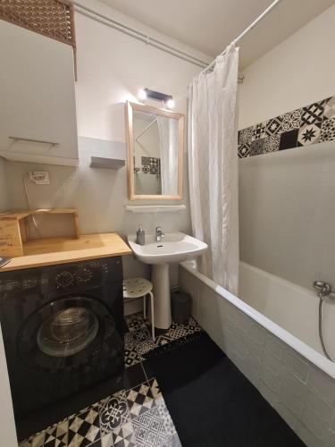La salle de bains est pourvue d'un lavabo et d'un lave-linge. dans l'établissement Appartement cosy 1 chambre, rénové avec terrasse exposée Sud, à Font-Romeu-Odeillo-Via