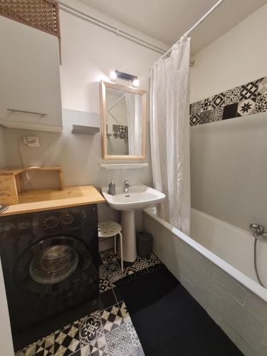 une salle de bain avec un lavabo et une machine à laver dans l'établissement Appartement cosy 1 chambre, rénové avec terrasse exposée Sud, à Font-Romeu-Odeillo-Via