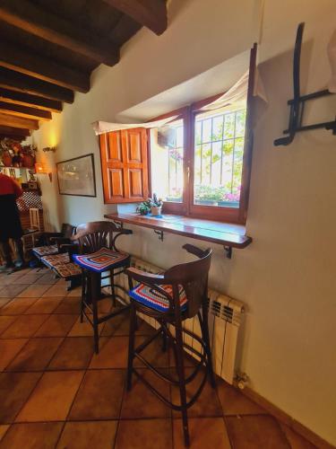 a kitchen with chairs and a table and a window at Albergue Laganares - Exclusivo para peregrinos in San Nicolás del Real Camino