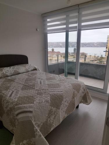 sypialnia z łóżkiem i dużym oknem w obiekcie Departamento Frente al Mar w mieście Coquimbo