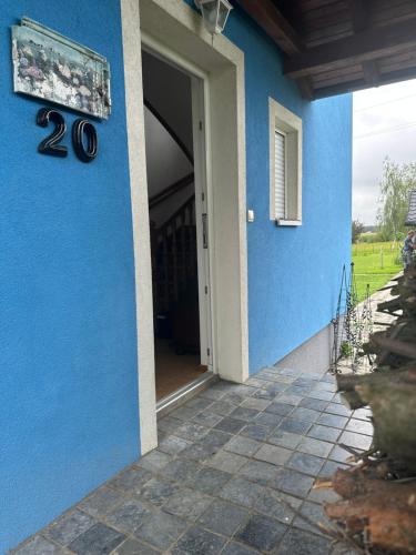 uma porta para uma casa com uma parede azul em Villa Plavi Lav Potok em Potok