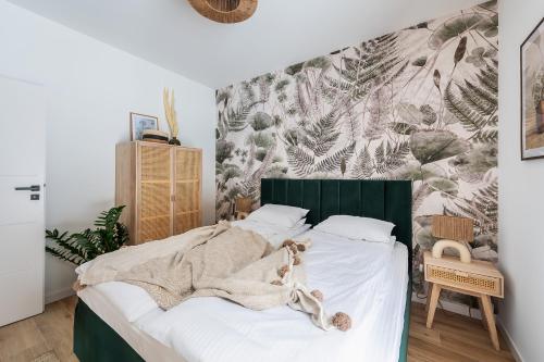 um quarto com uma cama com uma cabeceira verde em SZUMI ROSA 