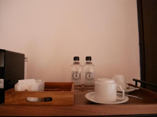 deux bouteilles d'eau et des tasses sur une table dans l'établissement Hotel El Farol, à Parras de la Fuente