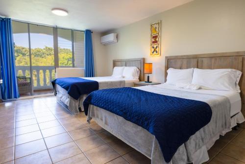 ein Hotelzimmer mit 2 Betten und einem Balkon in der Unterkunft Golden Dreams Studio 306 B in Isabela