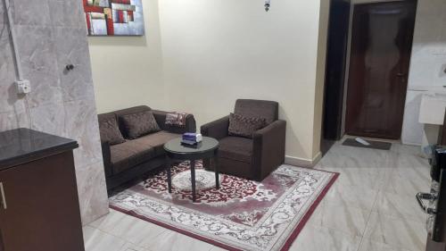 a living room with two chairs and a table at شقق مساكن السمو المخدومة in Ad Dawādimī