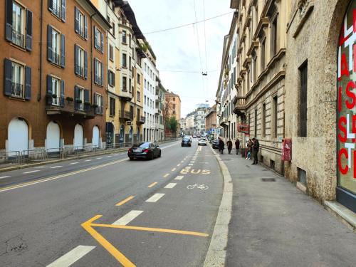 an empty city street with cars driving down the road at B and G San Babila luxury in the heart of Milano - Design district in Milan