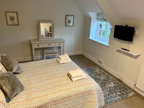 a bedroom with a bed with two towels on it at The Cottage in Abergavenny