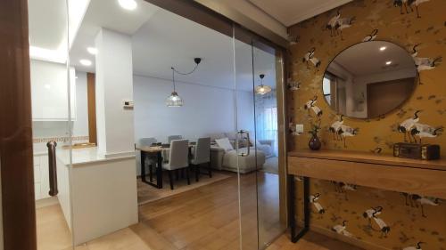 a bathroom with a mirror and a dining room at O pisiño de Vista Alegre in Vilagarcia de Arousa