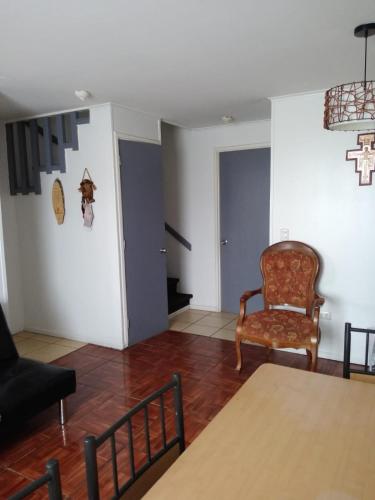 een woonkamer met een stoel en een tafel bij Arriendo casa muy buena ubicación en Villarrica in Villarrica
