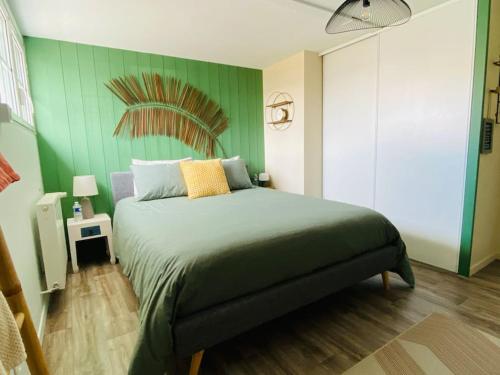 um quarto com uma cama com uma parede verde em Gite 3 chambres, pour ouvriers ou salariés em Coulon