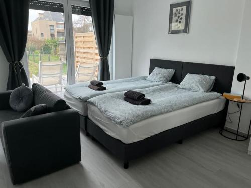 a bedroom with a large bed and a couch at Appartement Brussels Airport 2 in Machelen