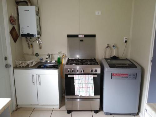 a kitchen with a stove and a sink at Arriendo casa muy buena ubicación en Villarrica in Villarrica