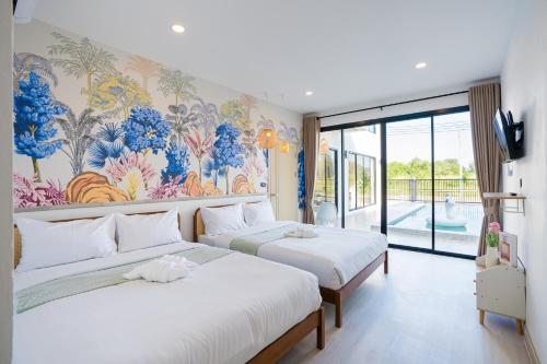 Dos camas en una habitación con un mural en la pared. en Eva PoolVilla Pattaya Bang Saray Beach 1 km, en Bang Sare