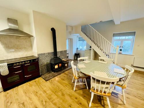 a kitchen and dining room with a table and a stove at The Cottage in Abergavenny