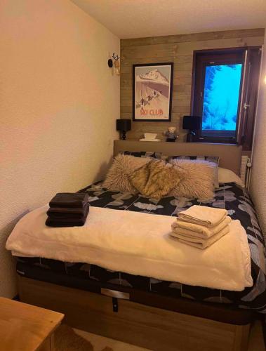 une chambre avec un lit avec des serviettes dessus dans l'établissement Résidence Les Grandes Bosses, à Courchevel