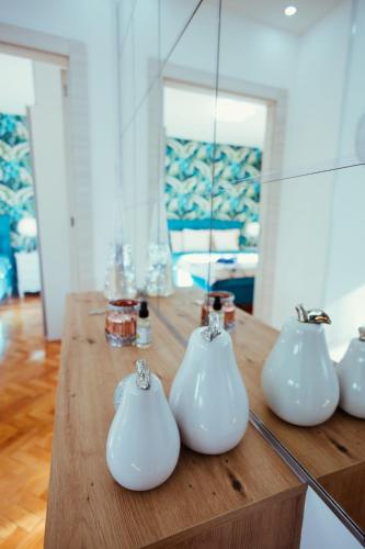 a table with four white vases on it at Apartman Milos, privatan parking in Kraljevo